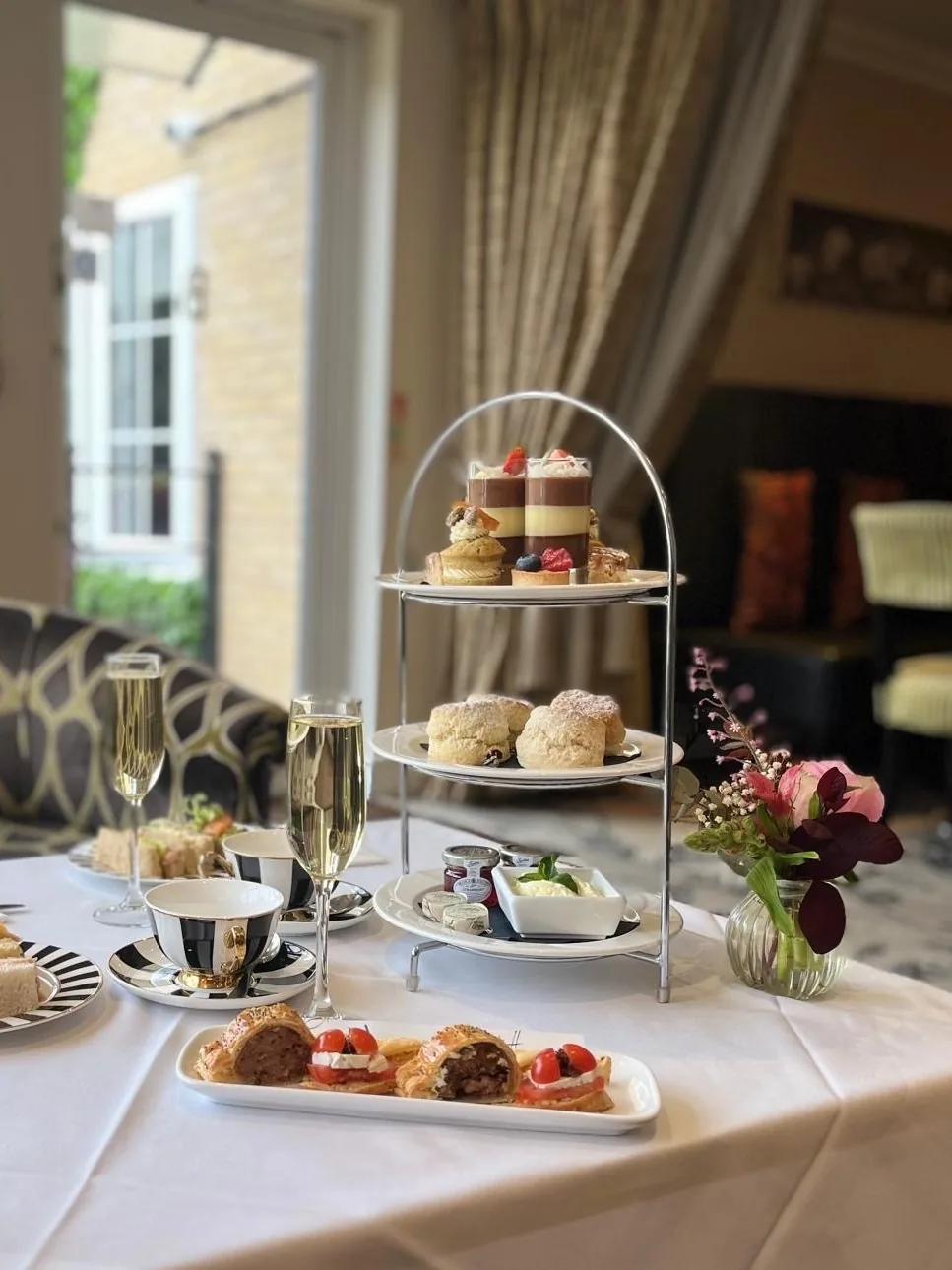 Afternoon tea stand with pastries, scones and Champagne in the lounge